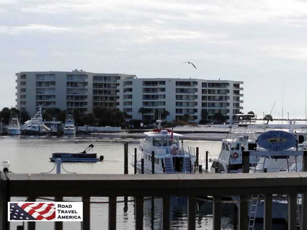 The Destin harbor with a part of the fishing fleet docked, with East Pass Towers in the distance