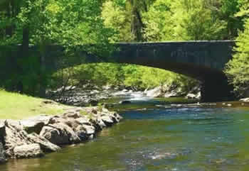 Stone bridge over a stream with rushing waters in the Great Smoky Mountains National Park