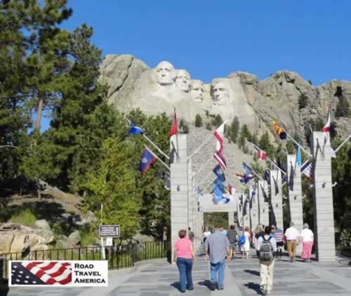 After purchasing tickets and parking, visitors walk through the Avenue of Flags as they approach the stone carvings at Mount Rushmore